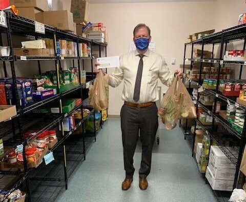 a masked man donating food