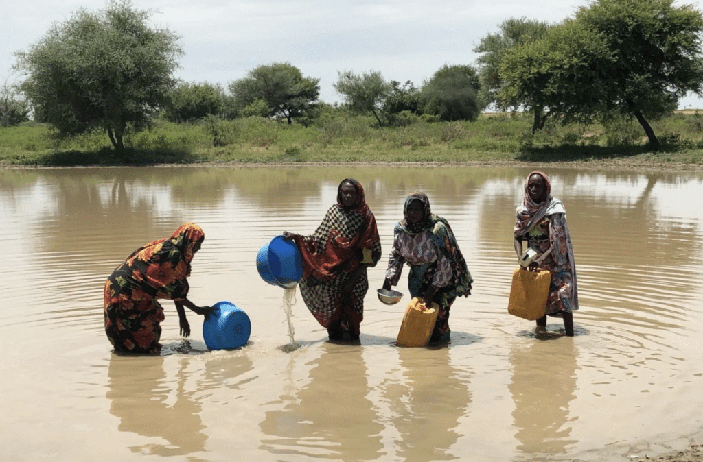 Women filling up water from a river