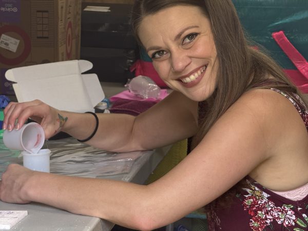 Close up of Kalli Fedusenko, founder of Savvy Advisor Marketing sitting at a table building Kevin Bacon mascot