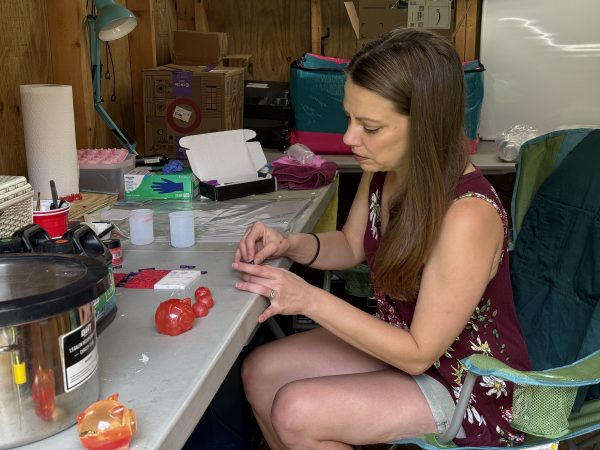 Kalli Fedusenko, founder of Savvy Advisor Marketing sitting at a table building Kevin Bacon mascot