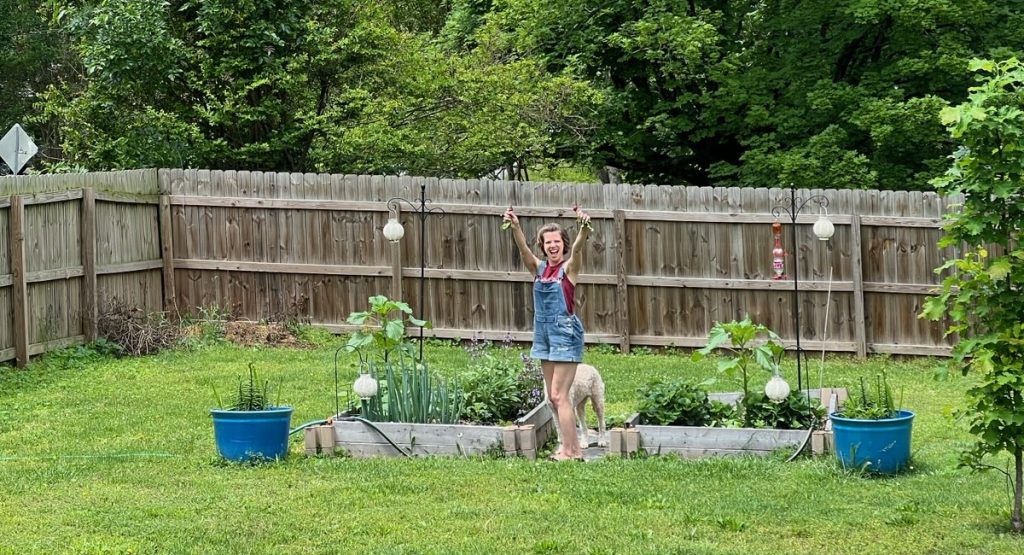 Kalli excitedly holding fruits from her garden harvest